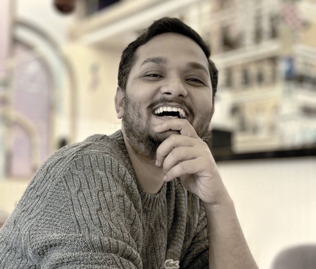 Akash laughing during a mentoring conversation at a cafe